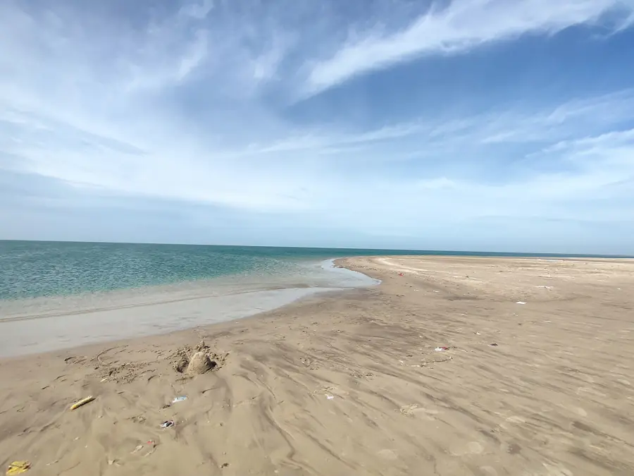 Paved road running out to Dhanushkodi with the sea on both sides under a bright sky